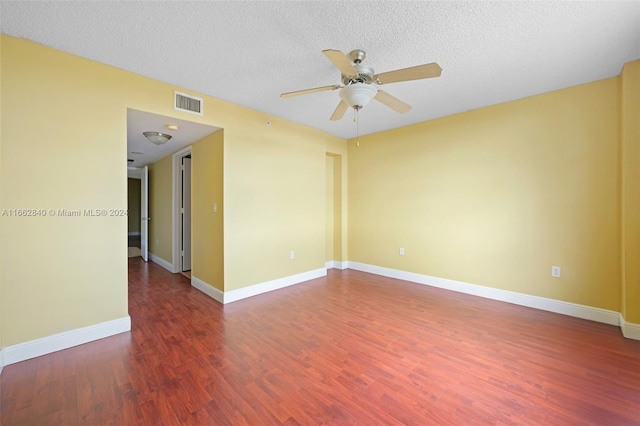 spare room with a textured ceiling, dark hardwood / wood-style flooring, and ceiling fan