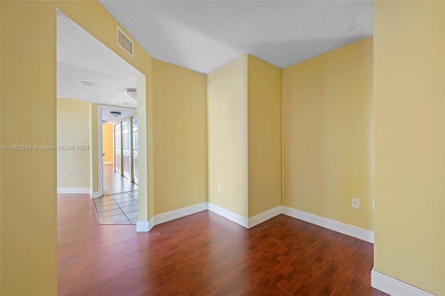 spare room with a textured ceiling and hardwood / wood-style floors