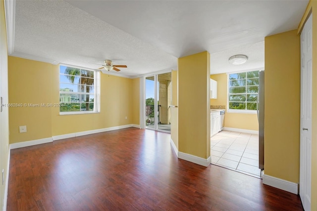 unfurnished room with wood-type flooring, ceiling fan, and a healthy amount of sunlight