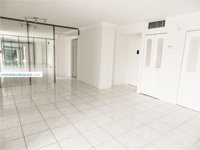 unfurnished room featuring crown molding and light tile patterned floors