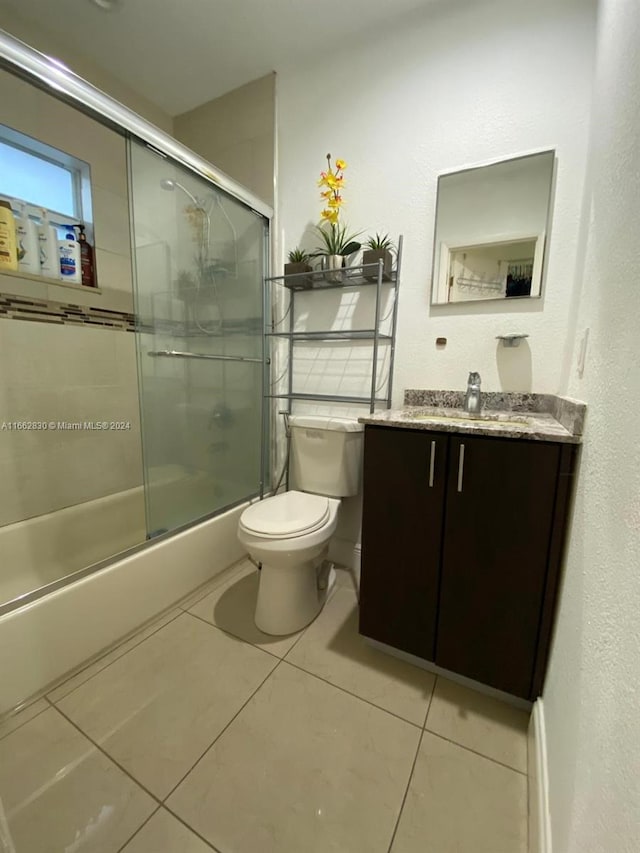 full bathroom with tile patterned flooring, vanity, enclosed tub / shower combo, and toilet