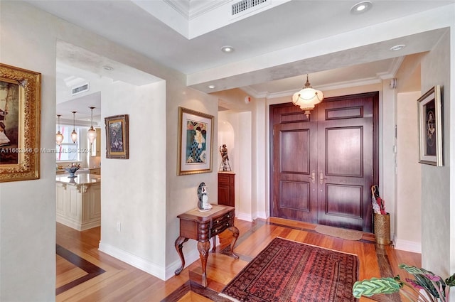 entryway featuring light hardwood / wood-style floors and crown molding