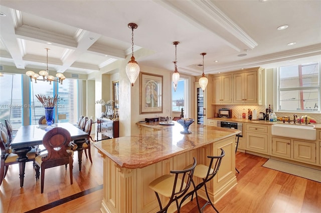 kitchen with a kitchen island, sink, light hardwood / wood-style floors, hanging light fixtures, and a chandelier