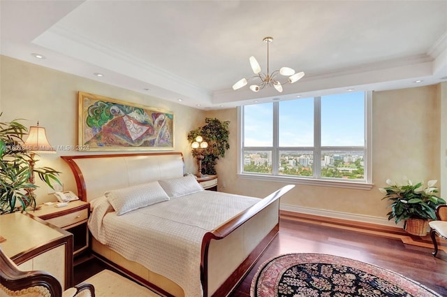 bedroom with ornamental molding, a chandelier, wood-type flooring, and a raised ceiling