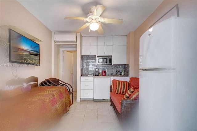 kitchen with ceiling fan, white appliances, an AC wall unit, white cabinetry, and decorative backsplash