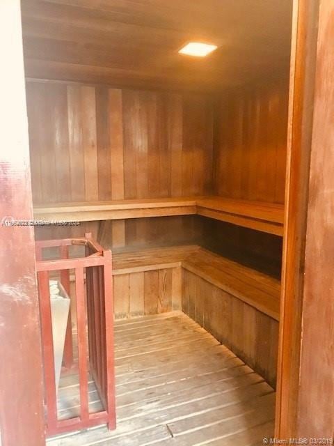 view of sauna / steam room featuring wooden walls and hardwood / wood-style floors