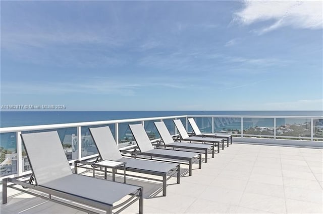 view of patio with a water view and a balcony