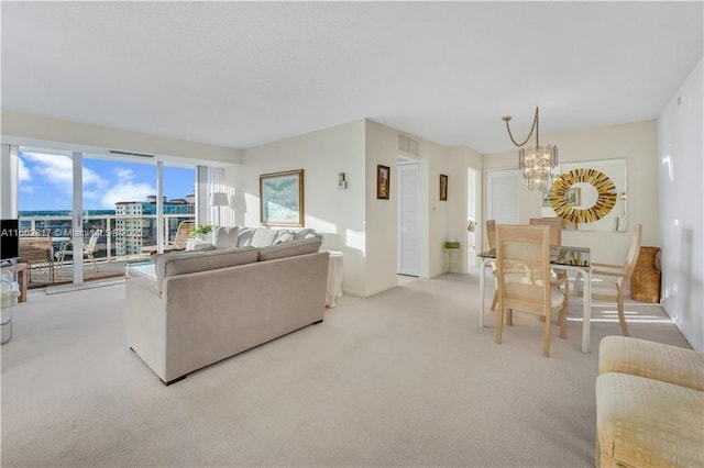 living room with light colored carpet and a notable chandelier