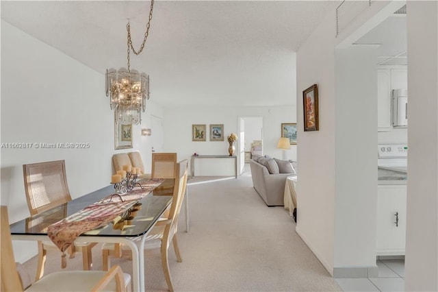 carpeted dining area with an inviting chandelier