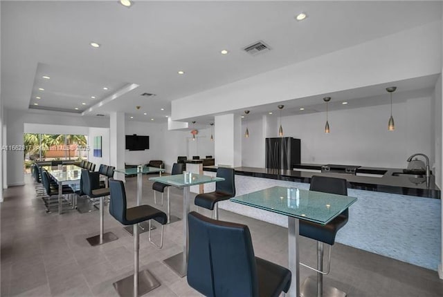 dining space with a tray ceiling and sink