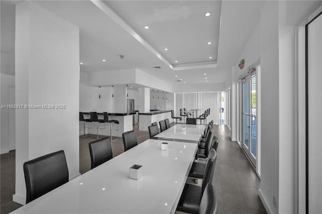 dining space with a raised ceiling