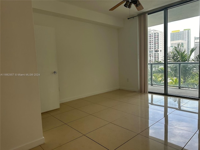 tiled spare room featuring ceiling fan