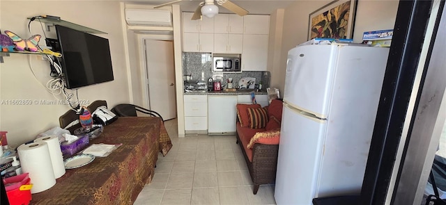 kitchen featuring decorative backsplash, white cabinetry, white refrigerator, and ceiling fan