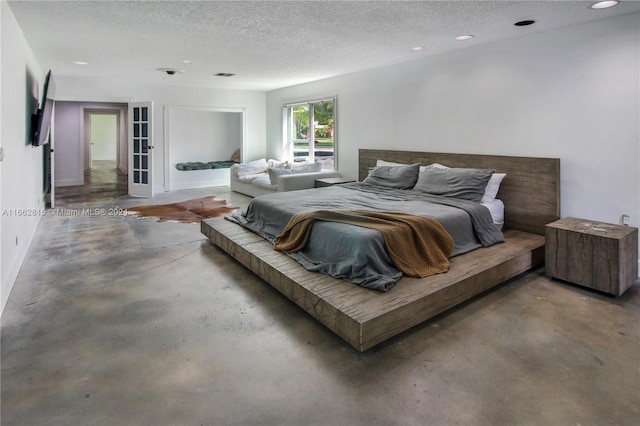 bedroom featuring concrete floors and a textured ceiling