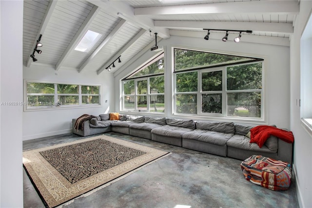 living room featuring concrete flooring and vaulted ceiling with skylight