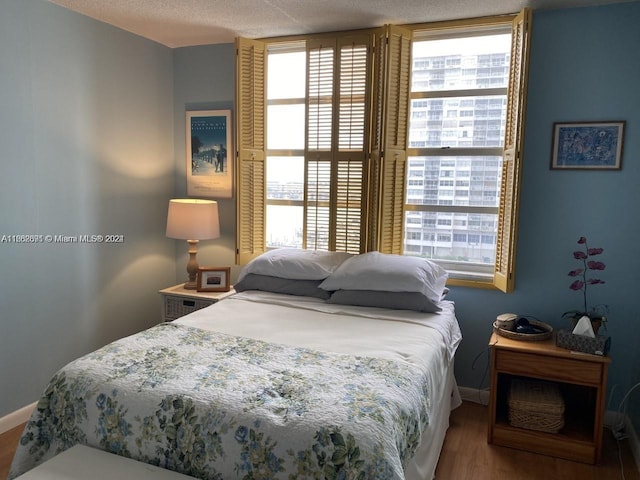 bedroom with hardwood / wood-style flooring and a textured ceiling