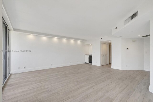 kitchen featuring white cabinetry, white refrigerator with ice dispenser, dishwasher, range hood, and sink