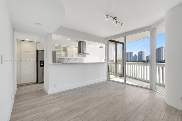 kitchen with stainless steel electric range, island range hood, white cabinets, a view of city, and a ceiling fan