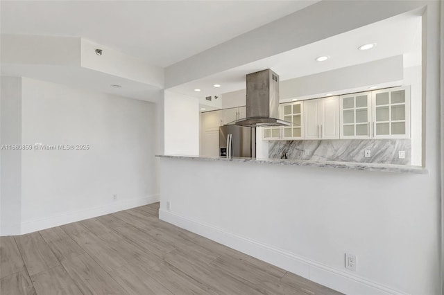 unfurnished room featuring a view of city, wood finished floors, a water view, and baseboards