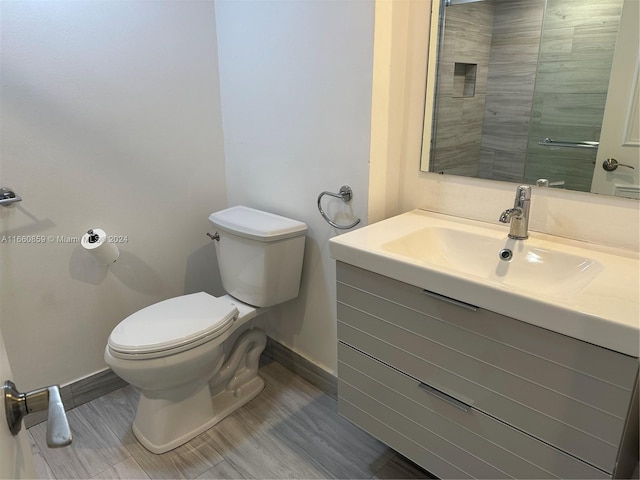 bathroom with hardwood / wood-style floors, vanity, and toilet