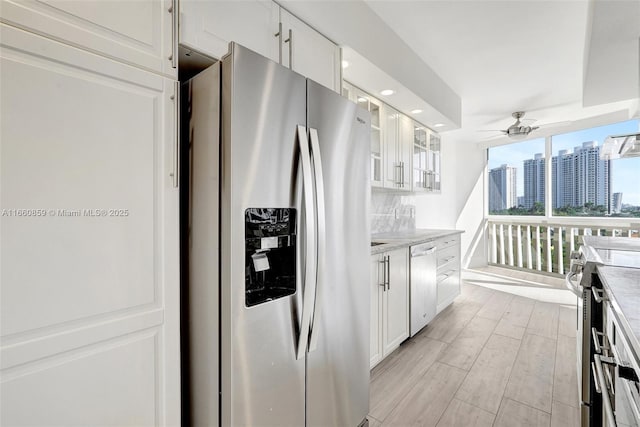 empty room with expansive windows, a water view, baseboards, and wood finished floors