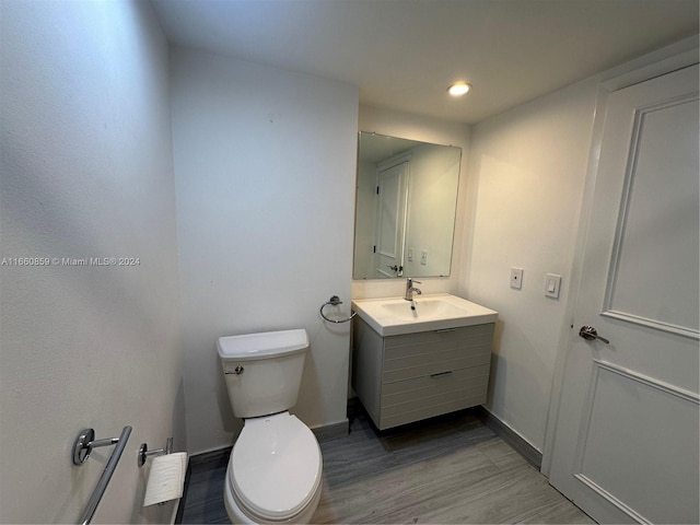 bathroom featuring hardwood / wood-style flooring, vanity, and toilet