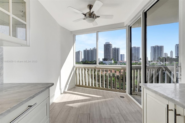 interior space featuring a city view, expansive windows, and wood finished floors