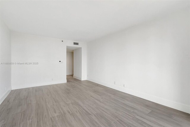 unfurnished room with visible vents, baseboards, and light wood-type flooring