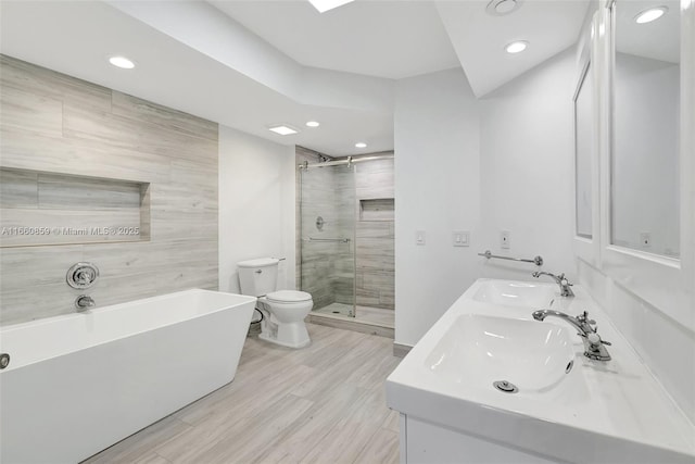 bathroom with a sink, toilet, tile walls, and a stall shower