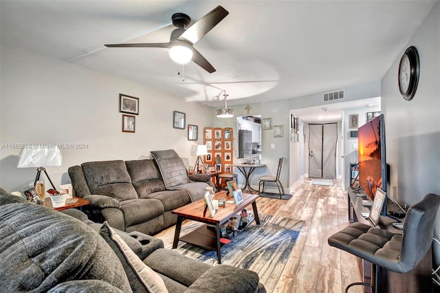 living room with ceiling fan and light hardwood / wood-style floors