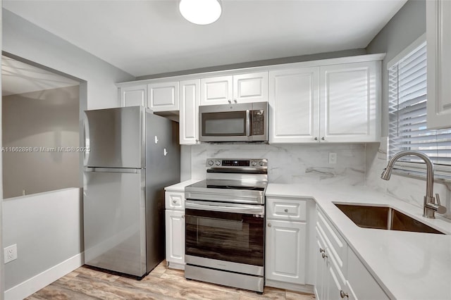 kitchen featuring white cabinetry, sink, backsplash, and appliances with stainless steel finishes