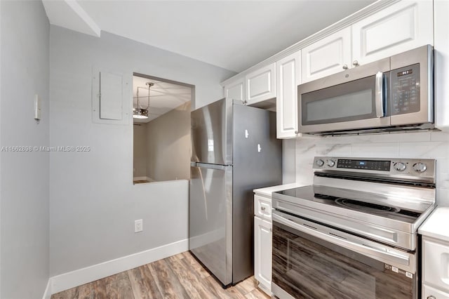 kitchen with decorative backsplash, light hardwood / wood-style floors, white cabinets, and appliances with stainless steel finishes