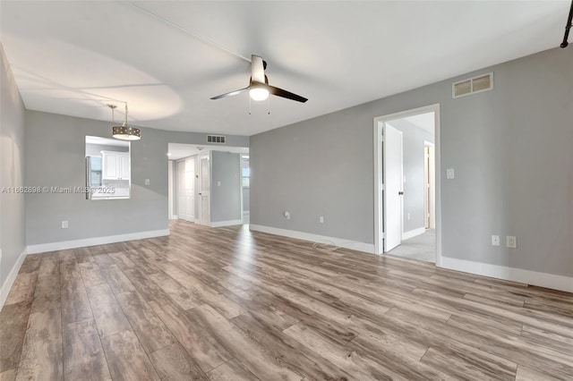 spare room with ceiling fan and light wood-type flooring