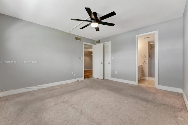 unfurnished bedroom featuring light carpet, ensuite bath, a closet, and ceiling fan