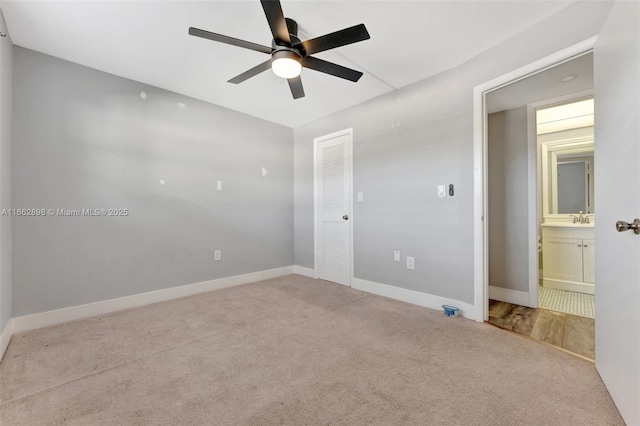carpeted empty room featuring sink and ceiling fan