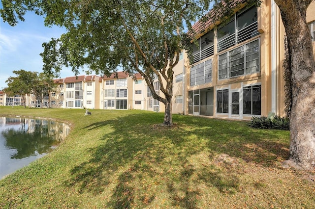 view of home's community featuring a water view and a lawn