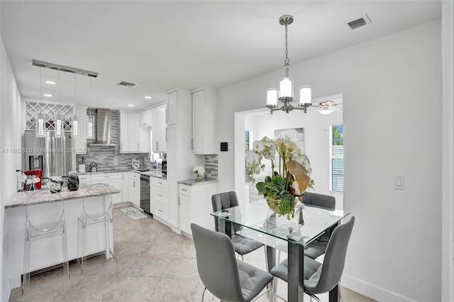 dining area with light tile patterned flooring and a chandelier