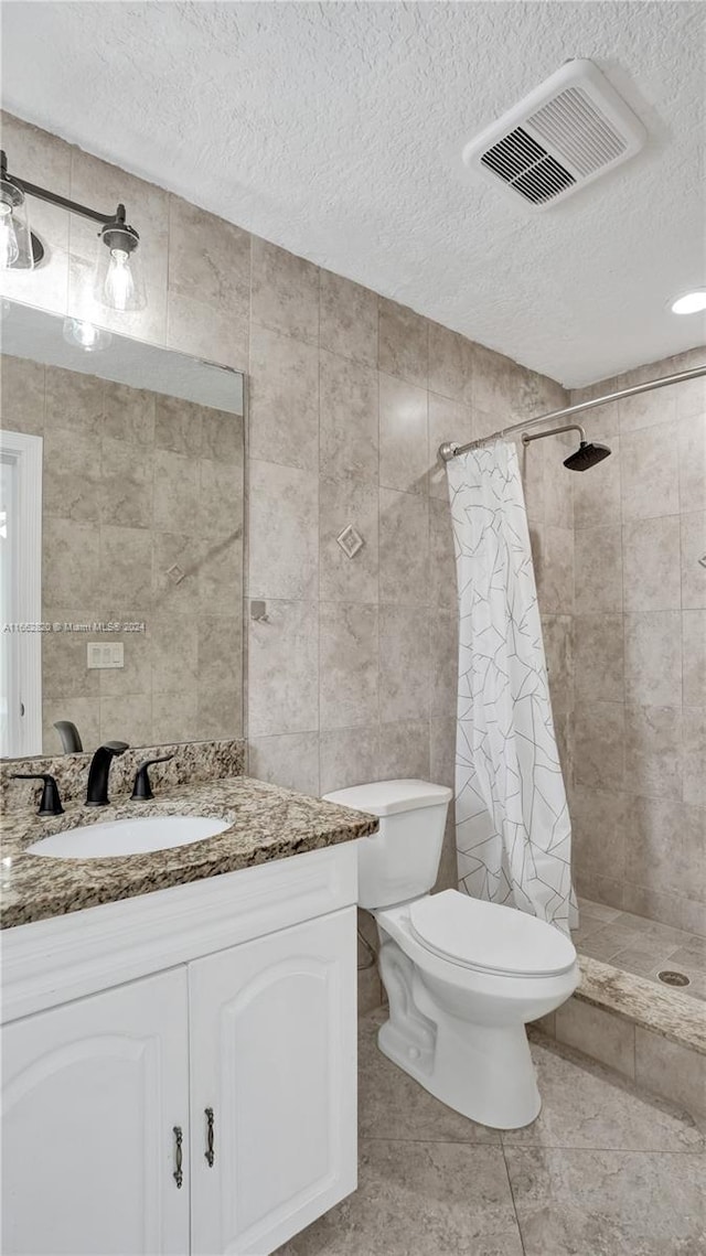 bathroom featuring tile walls, vanity, and toilet