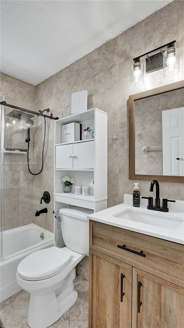 full bathroom with tile patterned floors, tiled shower / bath combo, vanity, and toilet