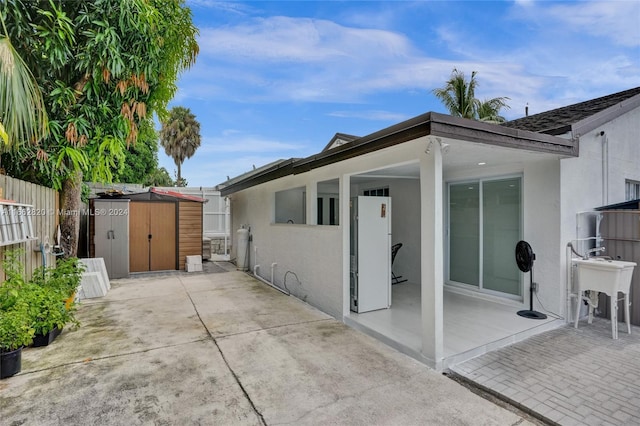 exterior space with a patio, sink, and a shed