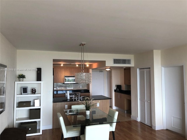 dining space with dark hardwood / wood-style floors and a chandelier