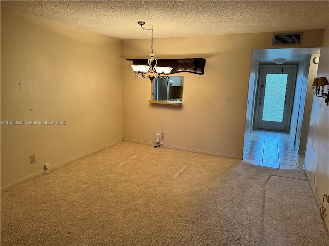 unfurnished room featuring carpet flooring, a textured ceiling, and a chandelier