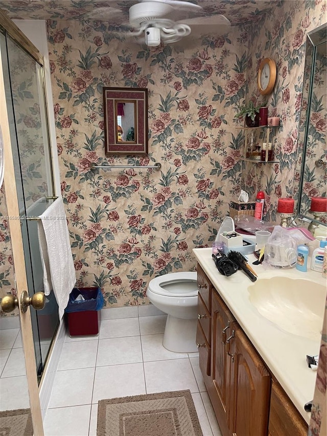 bathroom featuring vanity, toilet, an enclosed shower, and tile patterned floors