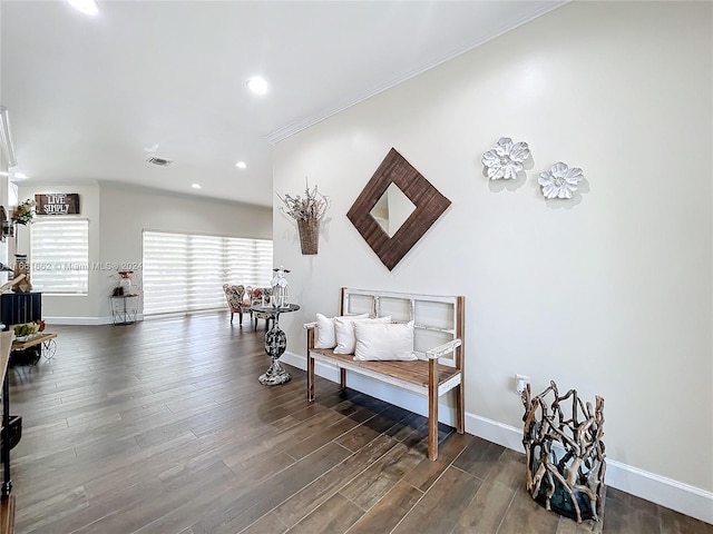 sitting room featuring a skylight, crown molding, and dark wood-type flooring