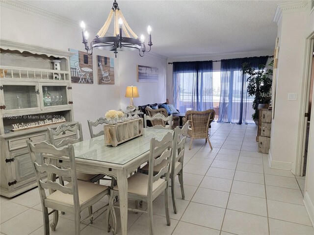 dining room featuring a notable chandelier, a textured ceiling, light tile patterned floors, and crown molding