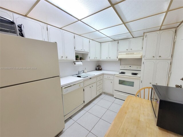 kitchen featuring sink, white appliances, and white cabinetry