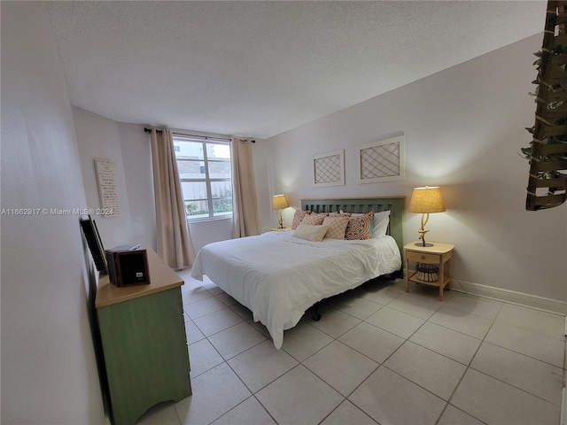 bedroom with tile patterned flooring and a textured ceiling