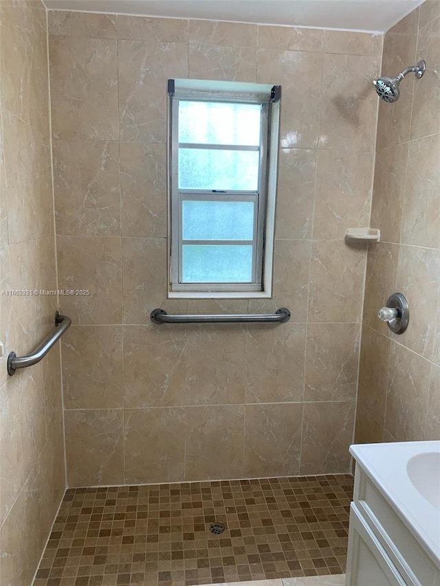 bathroom with vanity and tiled shower