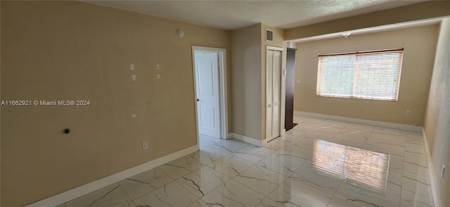 interior space featuring a textured ceiling and a closet