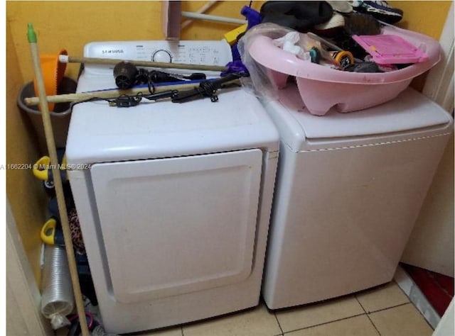 laundry area featuring washer and clothes dryer and light tile patterned floors